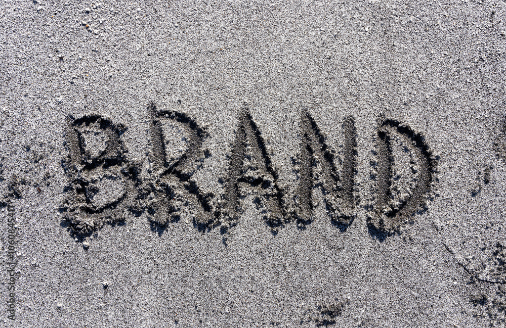 Fototapeta premium Business brand concept. Concept word brand written on beautiful ocean sand beach. Beautiful ocean sand beach background, copy space. Business brand concept.