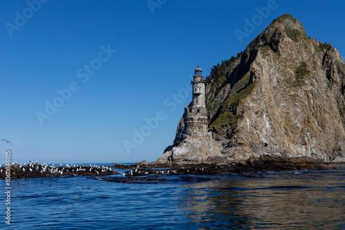 Aniva - The abandoned lighthouse in the Sakhalin Island, Korsakov district, Russia. Pacific ocean. The abandoned lighthouse Island Blue sea. Beautiful view. Blue sky and blue Pacific ocean. photo