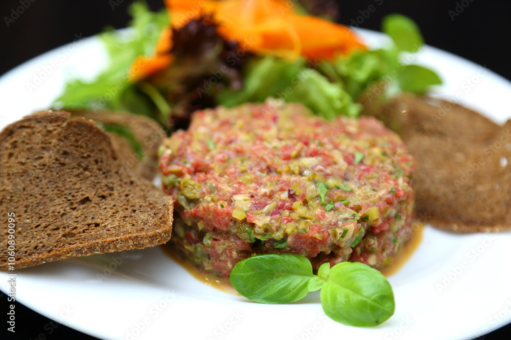Raw meat tartare for gourmets. Raw meat tartare with spices, croutons and herbs. Beef tartare with capers. Beef tartare with bread slices. Raw meat tartare for gourmets. Raw meat tartare with spices, croutons and herbs. Beef tartare with capers. Beef tartare with bread slices.