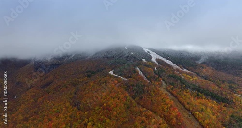 Autumn forests covering the mountain in Vermont, New England, USA. Thick fog hiding the peak. Aerial view. photo