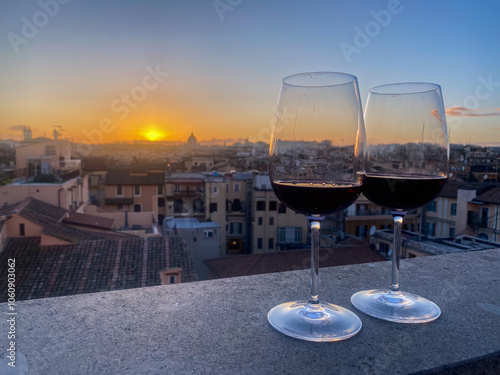 Photography Glasses of wine at sunset with rooftop view over rome italy