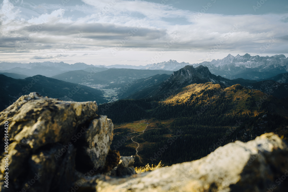 Fototapeta premium A stunning mountain range view with trees and rocks in the foreground