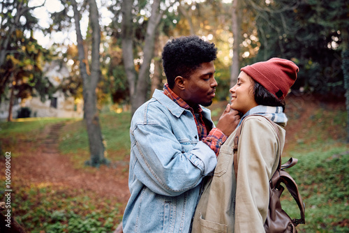 Young couple about to kiss in autumn park.