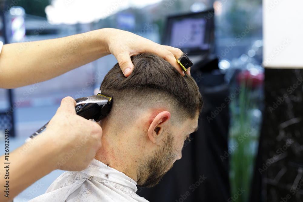 Men's haircutting with hair clipper in a barber shop or hair salon. Hairdresser service in a barbershop. Men's haircutting with hair clipper in a barber shop or hair salon. Hairdresser service in a barbershop.