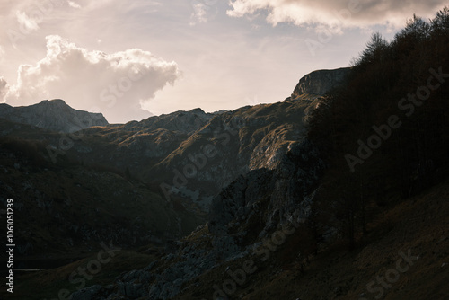 Beautiful mountain landscape with people hiking under the sun 
