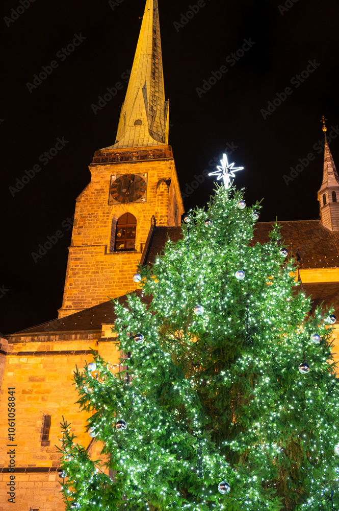 A festive scene with Christmas decorations in the foreground and the Cathedral of St. Bartholomew in Plzen, Czech Republic, in the background. A charming mix of tradition and holiday spirit