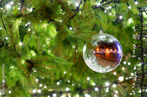 Obraz na płótnie A beautiful glass ornament hanging on a Christmas tree, reflecting the lively atmosphere of the square in Pilsen, capturing the essence of the holiday spirit w salonie