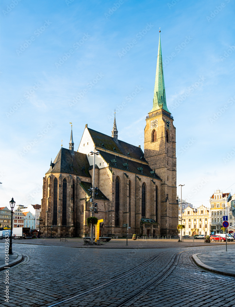 A photograph of the Cathedral of St. Bartholomew in Plzen, Czech Republic. This Gothic cathedral with its iconic tower stands proudly, surrounded by historic buildings, offering a stunning view