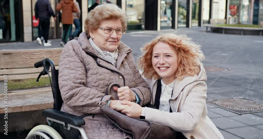 Happy young woman spending time with elderly lady in wheelchair outdoors. Smiling and caring relationship between generations. City background. Joyful Moments Between Grandmother and Granddaughter Happy young woman spending time with elderly lady in wheelchair outdoors. Smiling and caring relationship between generations. City background. Joyful Moments Between Grandmother and Granddaughter