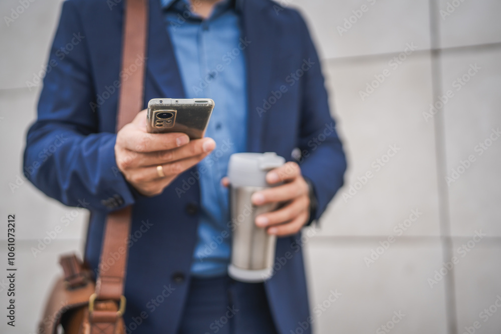 close up of unknown adult man hold mobile phone and thermos outdoor close up of unknown adult man hold mobile phone and thermos outdoor