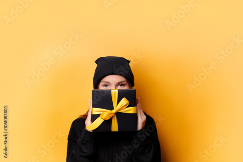 Black friday sale concept. Shopping woman holding grey bag isolated on dark background in blackfriday holiday. Black firday in neon lights. Covered face. photo