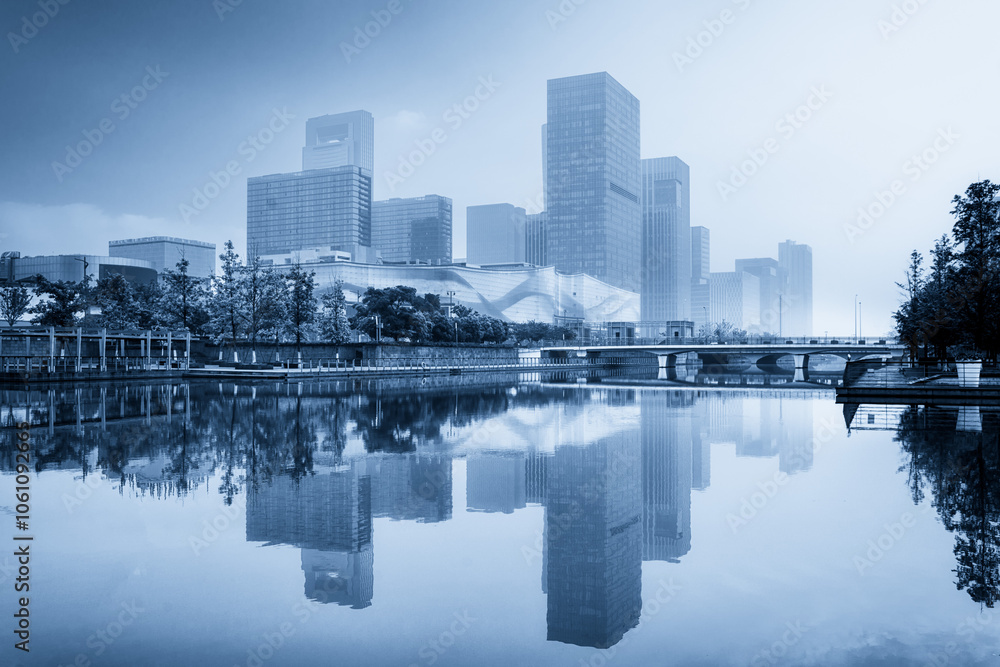 Fototapeta premium Serene Urban Landscape with Towering Skyscrapers Reflected in Calm Waters