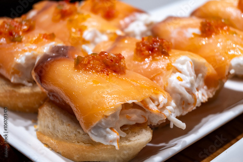 Typical snacks of Basque Country, pinchos or pinxtos skewers with small pieces of bread, fish, sea food, sweet green pepper served in bar in San-Sebastian or Bilbao, Spain photo