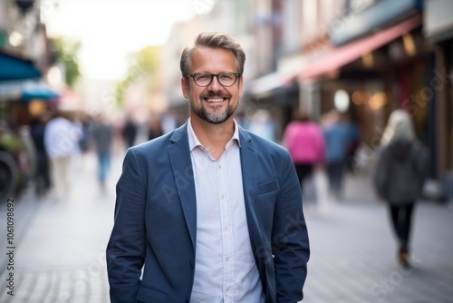 Portrait of a handsome mature man with glasses on a city street