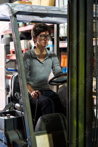 Warehouse worker driving forklift in logistics center