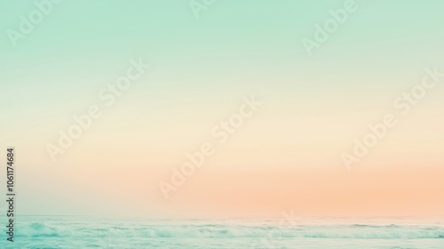 Soft pastel hues create a dreamy atmosphere as the sky blends seamlessly with the ocean waves during a serene sunset, offering a tranquil and picturesque view