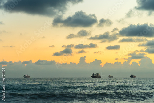 Schilderij op canvas Sea waves roll onto the pebbly shore against the background of the evening sunset sky with clouds