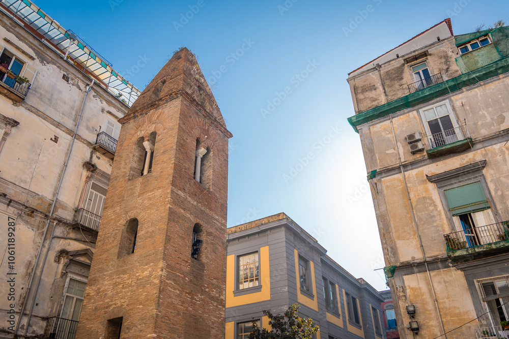 Belltower of pietrasanta complex is rising on the edge of a building in the narrow streets of Napoli old town. Small old brick belltower in the city Belltower of pietrasanta complex is rising on the edge of a building in the narrow streets of Napoli old town. Small old brick belltower in the city