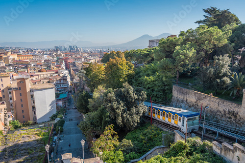 Funicular riding from the lower part of the napoli city towards the saint elmo fortress above the ground. Visible panorama of the napoli city with the white and blue funicular