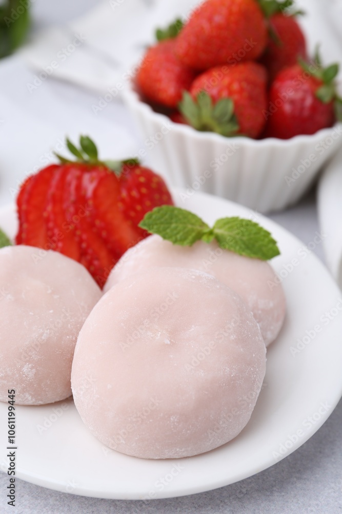Delicious mochi, strawberries and mint on light grey table, closeup Delicious mochi, strawberries and mint on light grey table, closeup