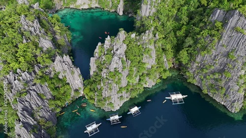 Stunning Aerial Sunset Panorama of Twin Lagoon on Coron Island, Philippines – Turquoise Waters, Small Boats, and Lush Green Cliffs in Breathtaking 4K Drone Footage