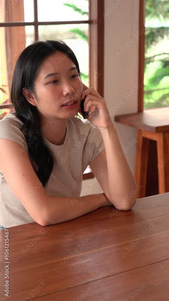 Woman talking on a phone while sitting in a cafe
