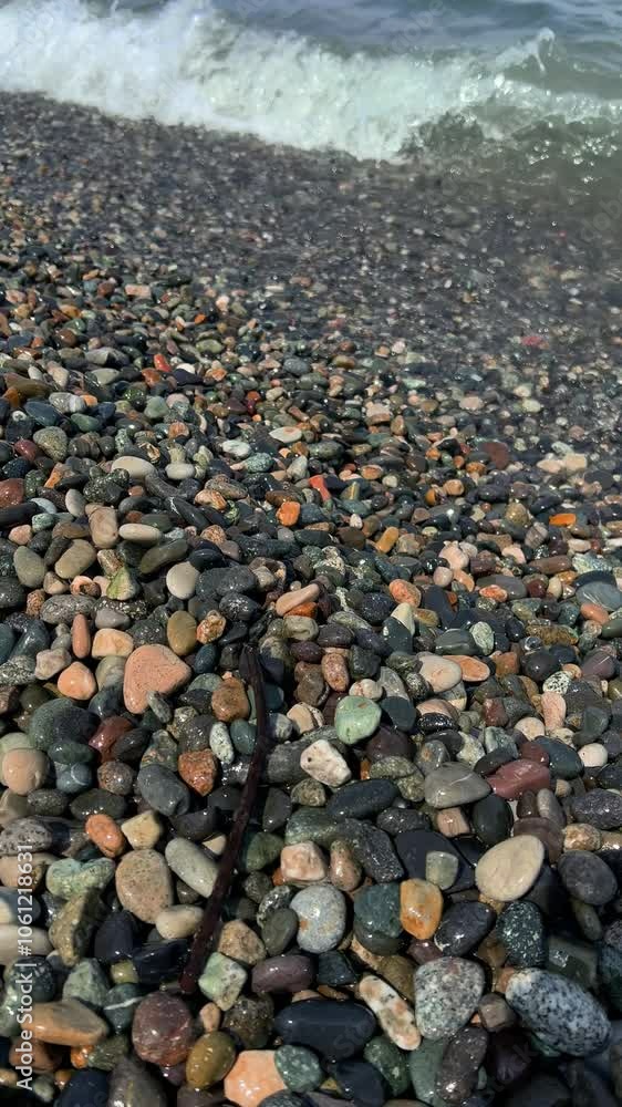 Sea water on pebble beach of Batumi. Ocean wave with foam rushes onto shore. Concept of tourism, travel, adventure, summer vacation, weekend, holiday, hotel, meditation, relax, rest. Vertical 4K video Sea water on pebble beach of Batumi. Ocean wave with foam rushes onto shore. Concept of tourism, travel, adventure, summer vacation, weekend, holiday, hotel, meditation, relax, rest. Vertical 4K video