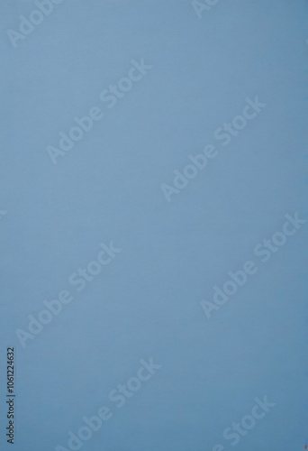 A plain blue background with a subtle texture, resembling a soft, muted blue paper or fabric