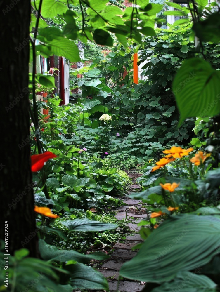 A lush garden pathway surrounded by vibrant foliage and colorful flowers. A lush garden pathway surrounded by vibrant foliage and colorful flowers.