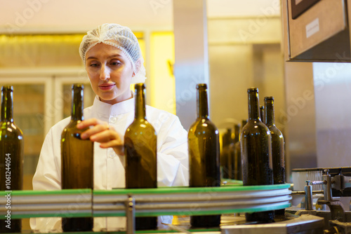 QA officer performs quality inspection of beverage bottles. photo