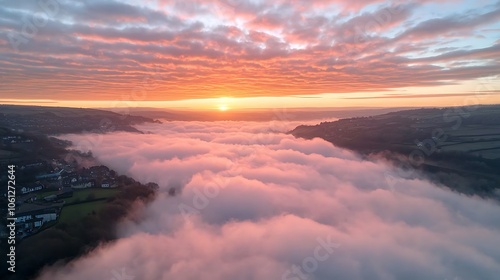 Breathtaking aerial view captures vibrant sunrise above rolling clouds in serene landscape