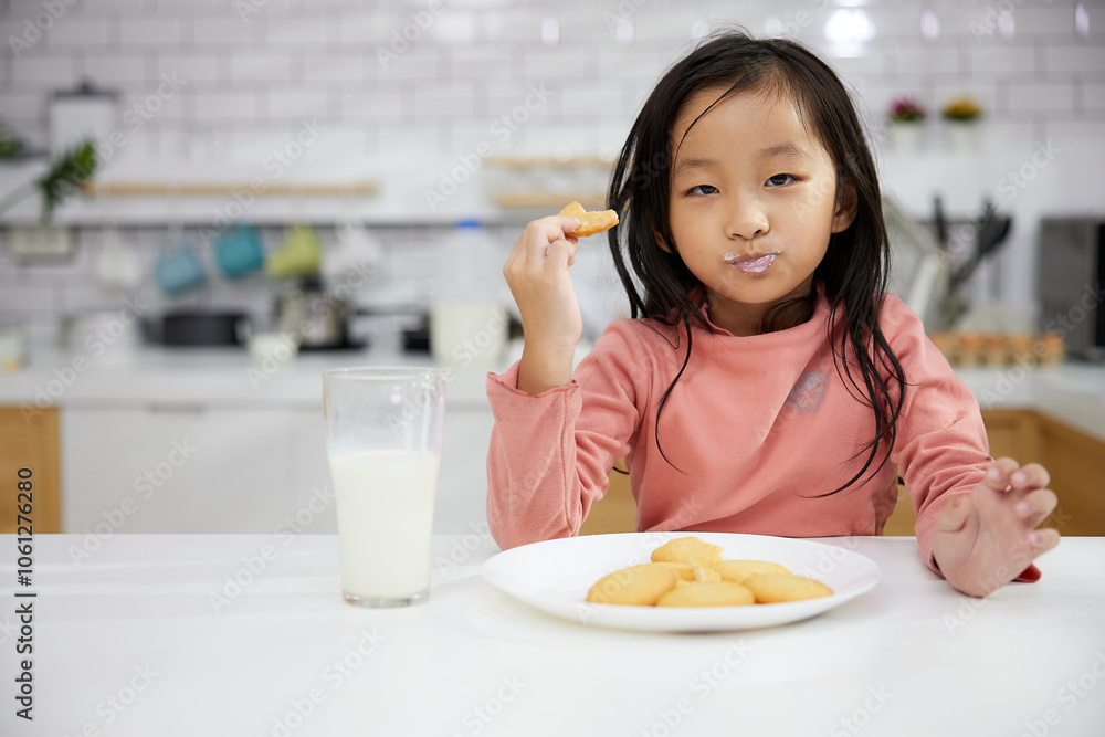 Portrait child girl enjoy eating cookies and drinking milk in the kitchen Portrait child girl enjoy eating cookies and drinking milk in the kitchen