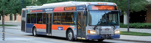 A city bus parked on a street, ready for passengers with destination signs displayed.