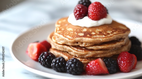 Delicious pancakes topped with fresh berries and whipped cream, perfect for breakfast or brunch.