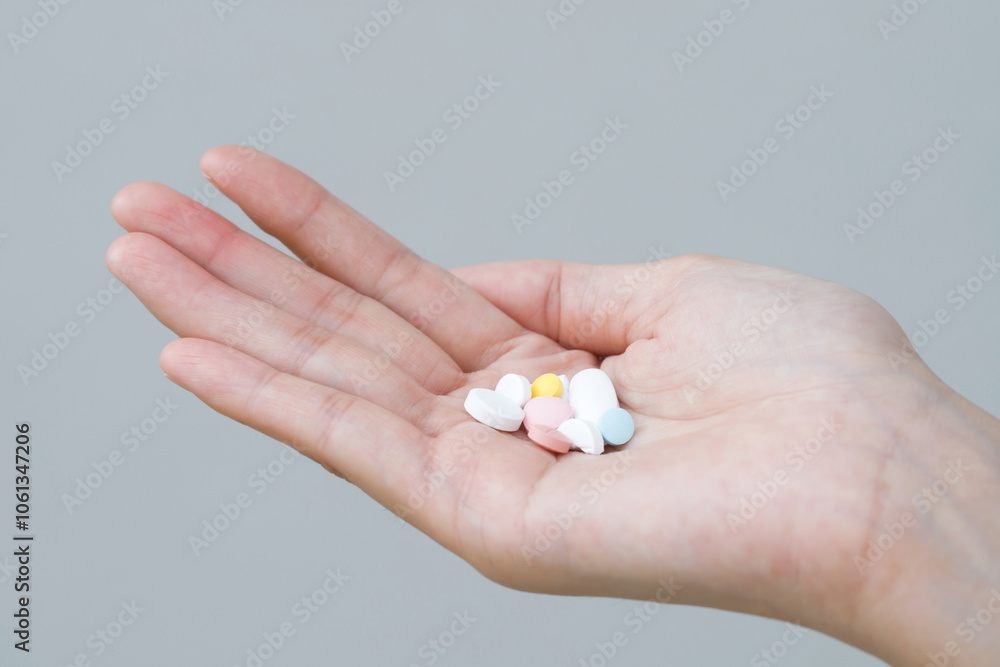 close up hand man taking multiple colors pills in hand. Stop drug use Taking Medication health care medical concept close up hand man taking multiple colors pills in hand. Stop drug use Taking Medication health care medical concept