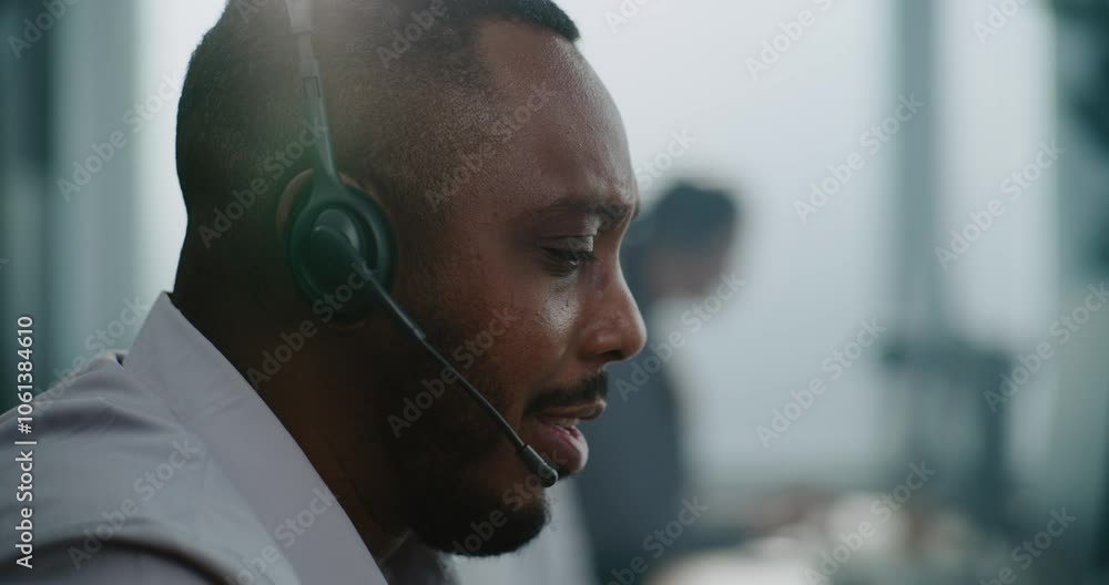 Close up portrait of African American technical support specialist in headset having conversation with client, helping online on phone call. Customer experience officer works in call center office.