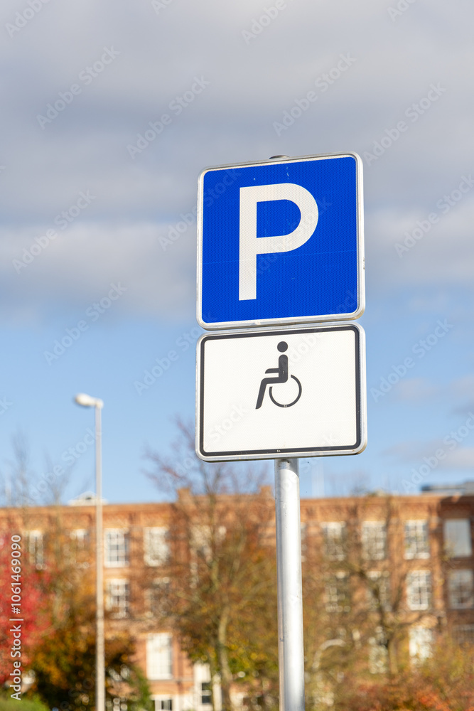 A blue parking sign indicating designated parking for people with disabilities. The sign has a wheelchair icon on a white background A blue parking sign indicating designated parking for people with disabilities. The sign has a wheelchair icon on a white background