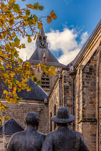 Bild auf Leinwand Kirche auf dem Marktplatz von Oldenzaal bei klarem Himmel Zwei Skulturen schauen auf die Kirche