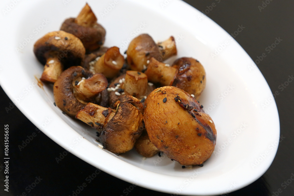 Fried champignons on a white oval plate. Fried champignons on a white oval plate.