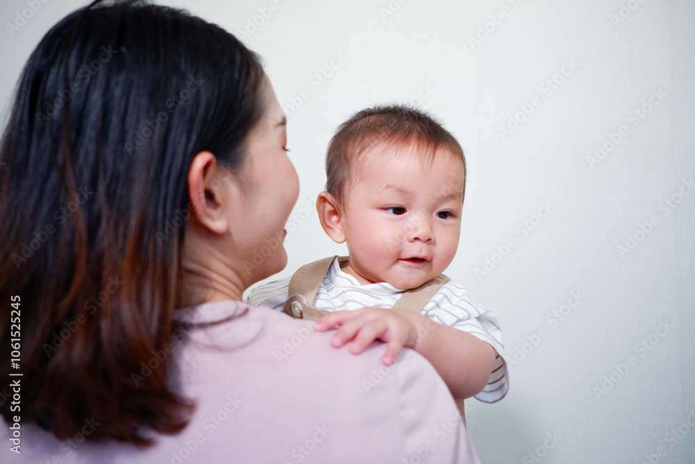 The mother is holding a baby and smiling. The mother is holding a baby and smiling.