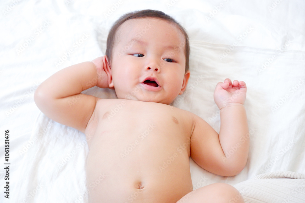 Cute little baby smiling and lying on a white bed. Cute little baby smiling and lying on a white bed.