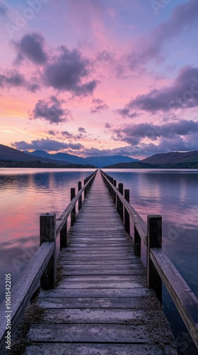 A serene sunset over a tranquil lake with a wooden pier extending