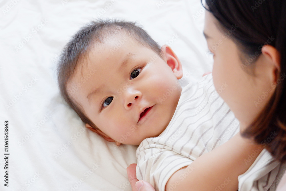 A cute mother and baby are playing on the bed. A cute mother and baby are playing on the bed.
