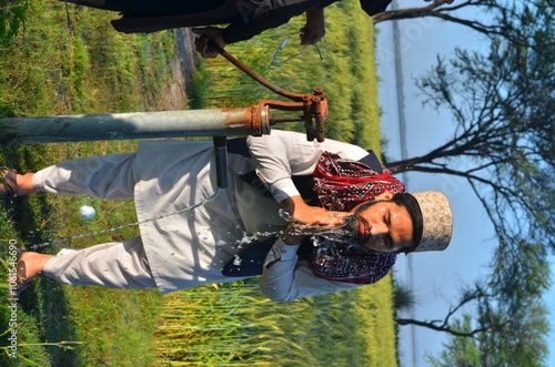 person with chainsaw / one boy face wsahing in nalka  photo