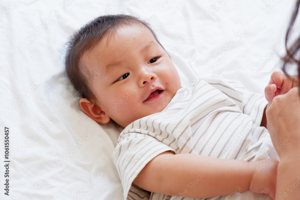 A cute smiling little baby is sleeping on a white bed. A cute smiling little baby is sleeping on a white bed.