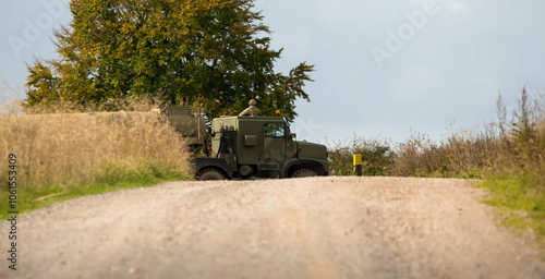British army Oshkosh 6x6 wheeled tanker Logistic Support and Transport Regiments pulling a fuel tanker on a dirt road