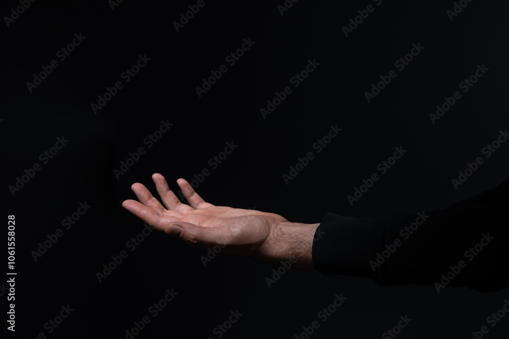 Open hand of a person against a dark background. Open hand of a person against a dark background.