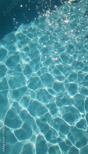 An inviting view of clear pool water with sunlight casting patterns on the surface, ideal for summer relaxation.