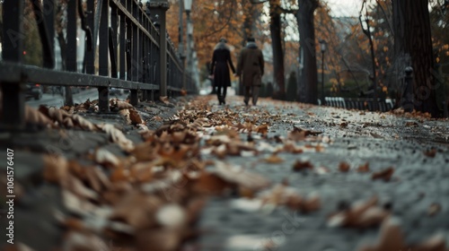 Two silhouetted figures walk down a leaf-covered path, encapsulating intimacy against an autumn backdrop.