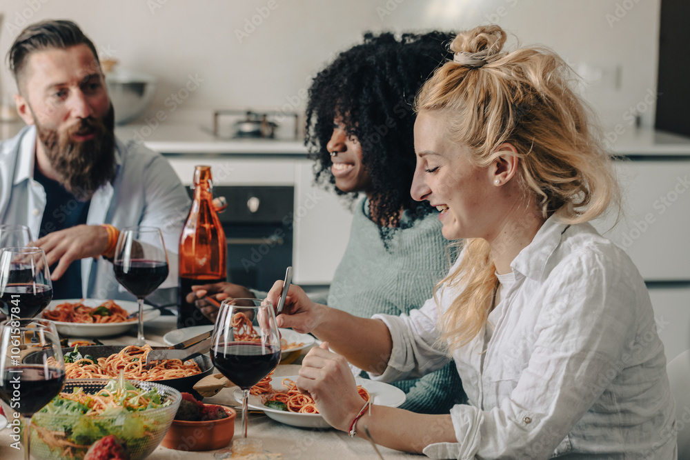 Happy friends eating spaghetti and drinking red wine at home Happy friends eating spaghetti and drinking red wine at home